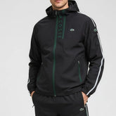 Black jacket with green accents and Lacoste branding on a gray background